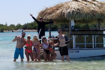 a group of people standing next to a tiki boat